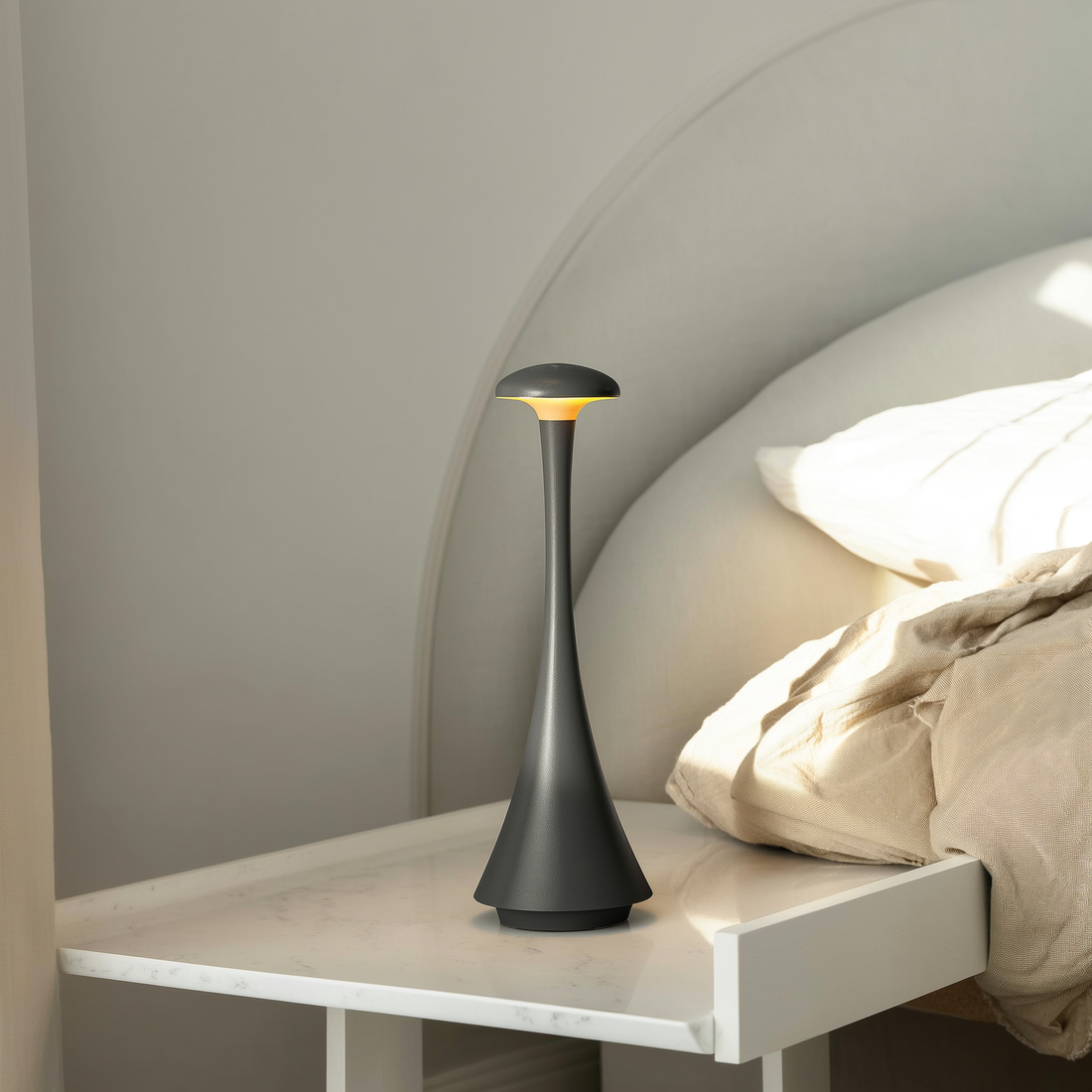 Abajur de mesa recarregável cinza na mesa de cabeceira de um quarto com roupa de cama de linho — foto de ambiente 1