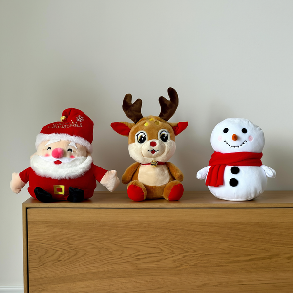 Trio de pelúcias de Natal com Papai Noel rena e boneco de neve sobre aparador — foto de ambiente 2
