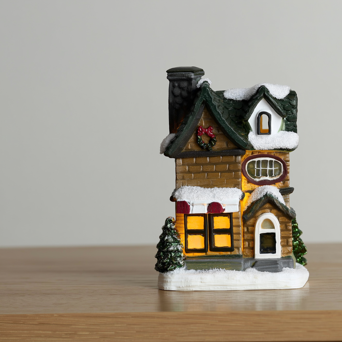 Casinha de Natal iluminada de resina com telhado nevado sobre a mesa — foto de ambiente 2