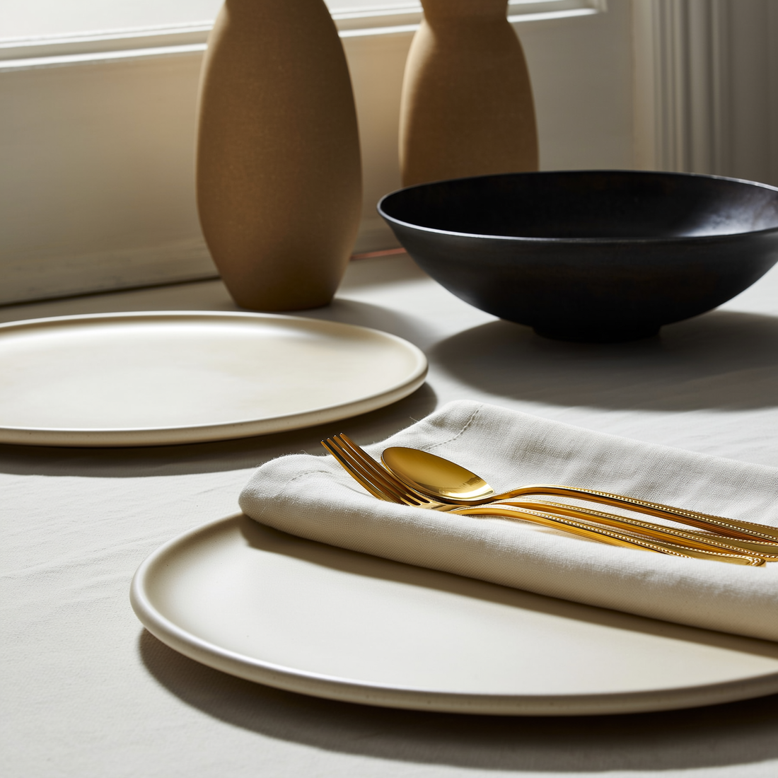 Faqueiro dourado de aço inox 16 peças disposto em mesa posta com pratos e linho — foto de ambiente 1