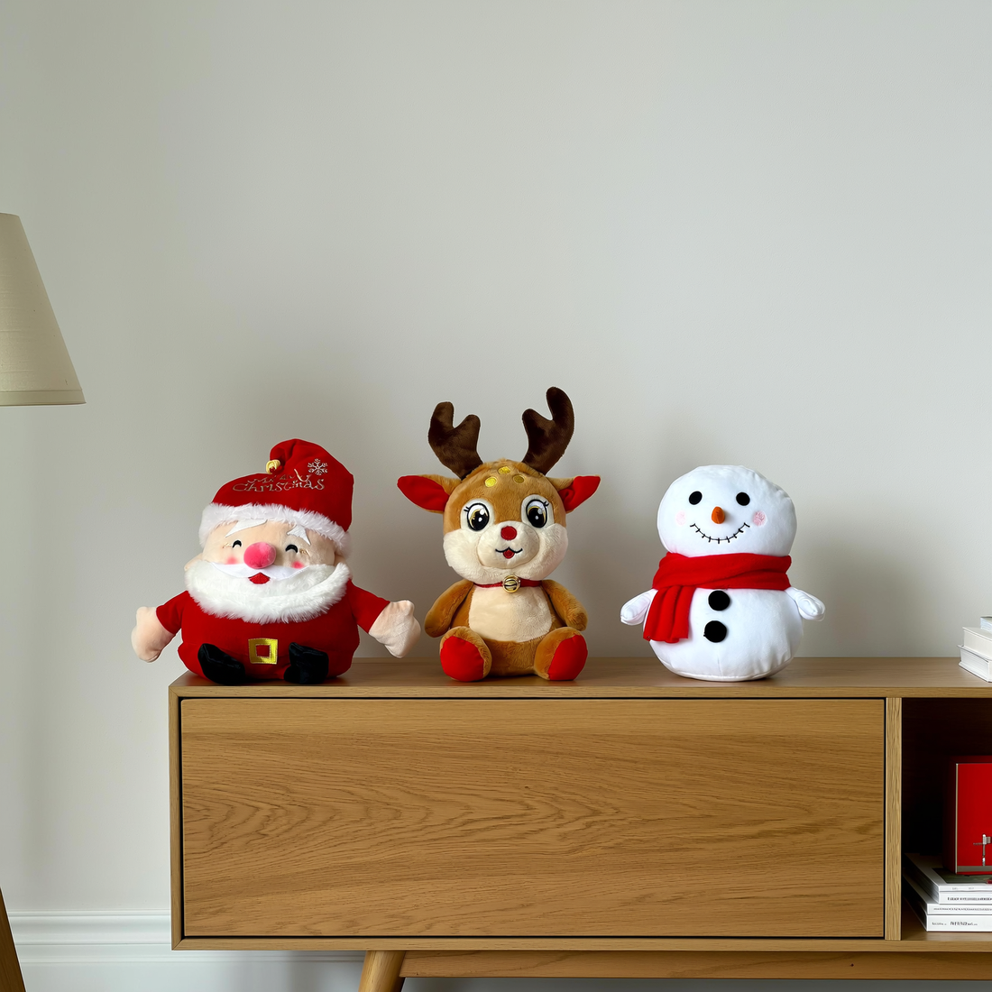 Trio de pelúcias de Natal com Papai Noel rena e boneco de neve sobre aparador — foto de ambiente 1