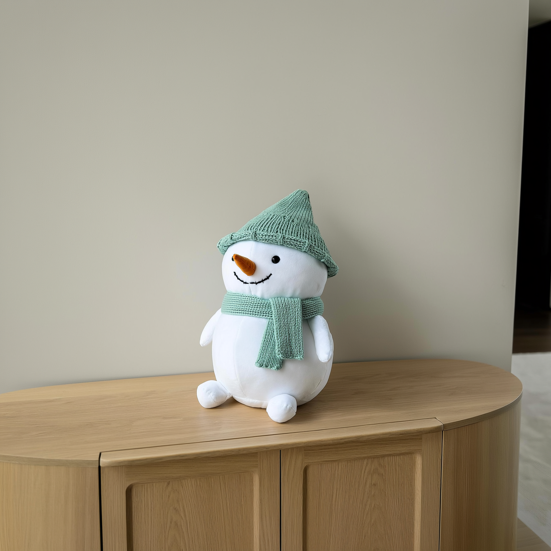 Boneco de neve de pelúcia com touca e cachecol verdes sobre aparador de madeira — foto de ambiente 2