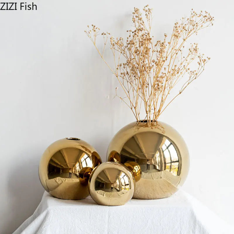 Vaso decorativo dourado arredondado sobre a mesa de centro