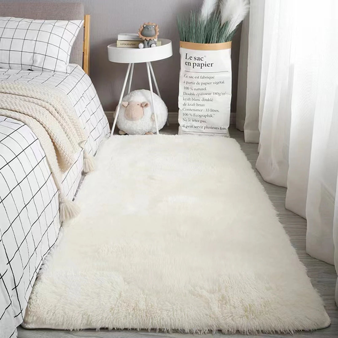 Tapete peludo branco estendido no piso da sala em frente ao sofá