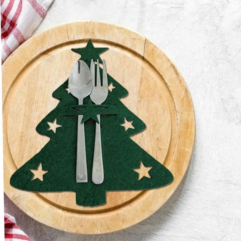 Quatro porta talheres de natal vermelhos em TNT, com desenho de rena, sobre a mesa posta