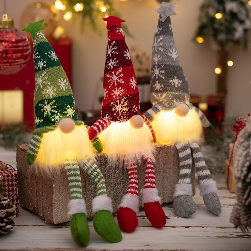 Elfo luminoso de Natal em tecido com LED aceso, apoiado em uma mesa lateral no escuro
