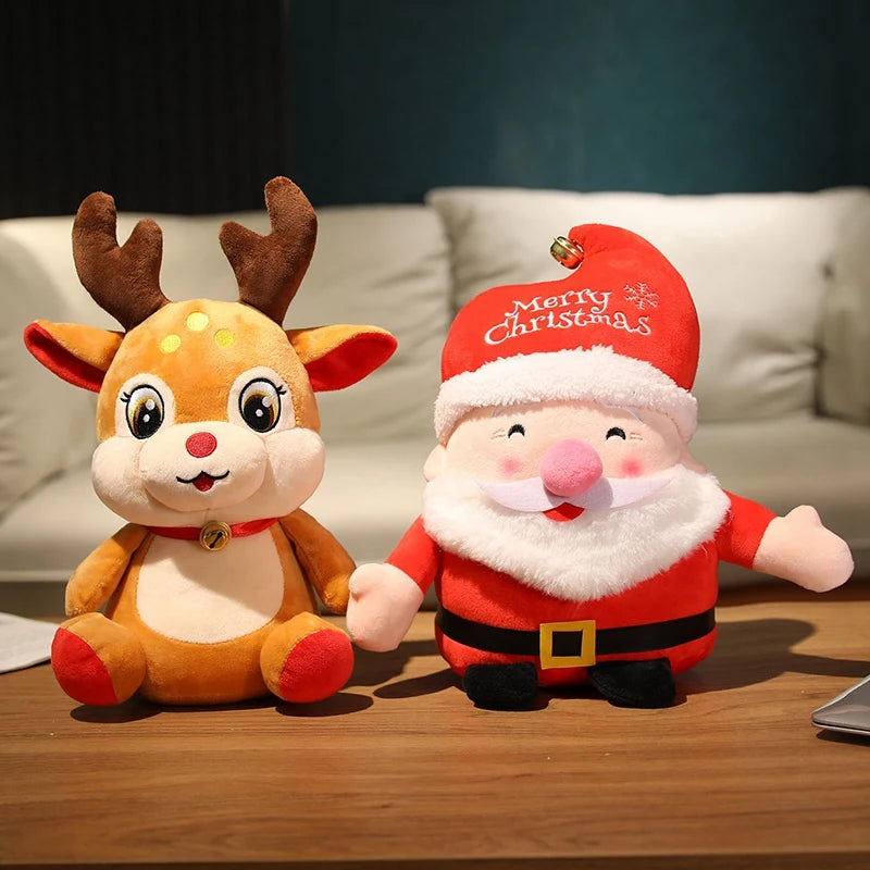 Três pelúcias de Natal de 20 cm — Papai Noel, rena e boneco de neve — enfileiradas sobre uma prateleira