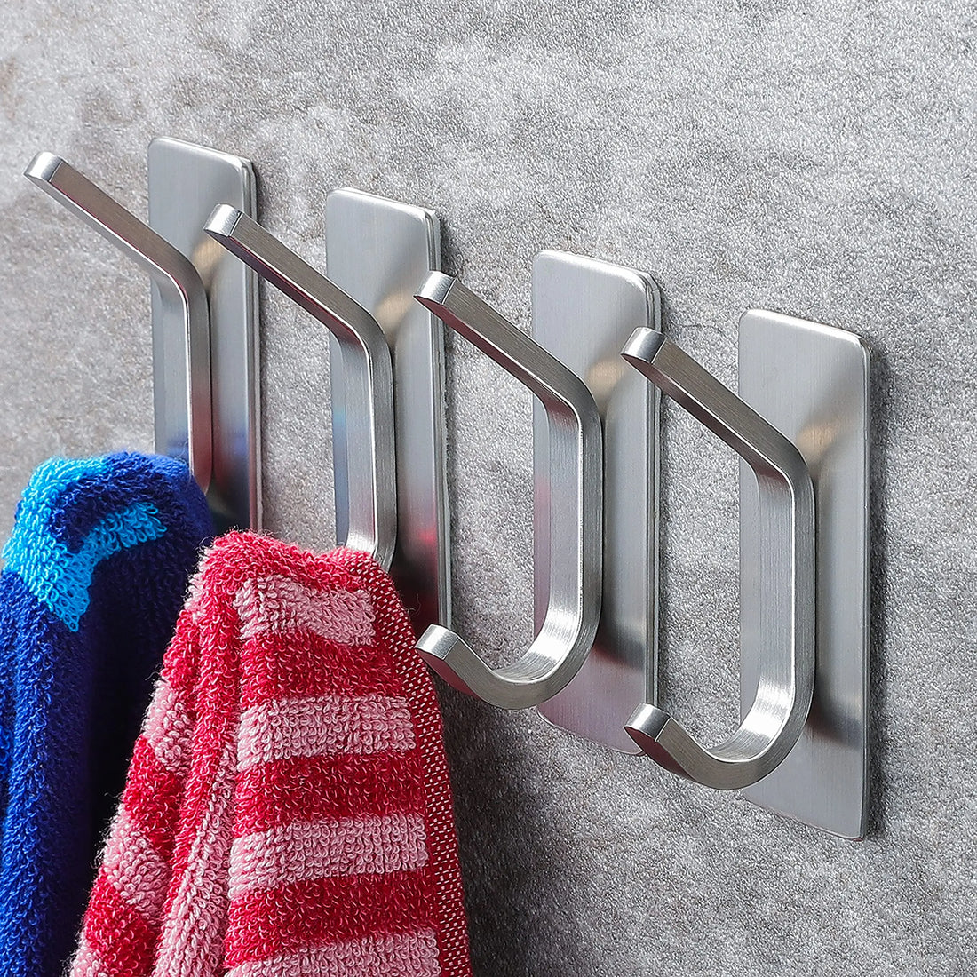 Kit de quatro ganchos de inox colados na parede do banheiro com toalha pendurada