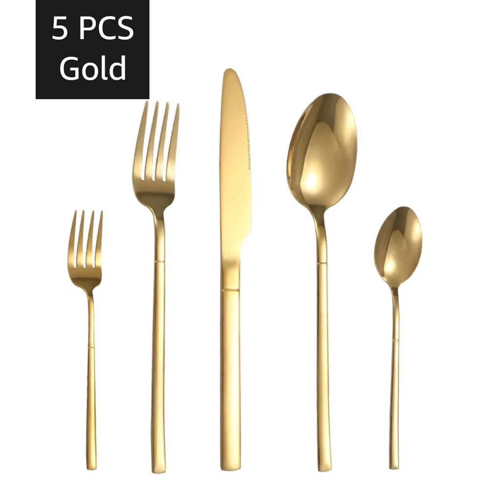 Kit de talheres dourado com cinco peças sobre a toalha branca
