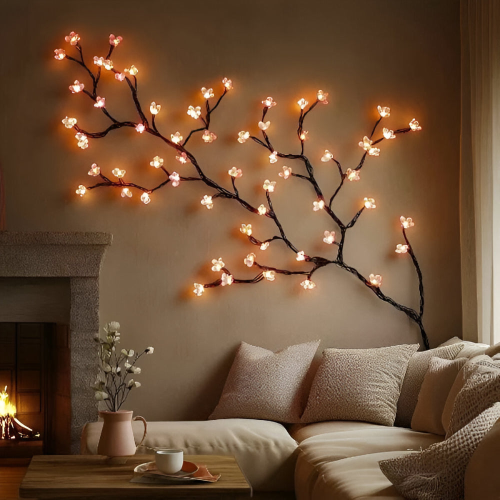 Galho decorativo com luzes de LED acesas fixado na parede acima de um sofá