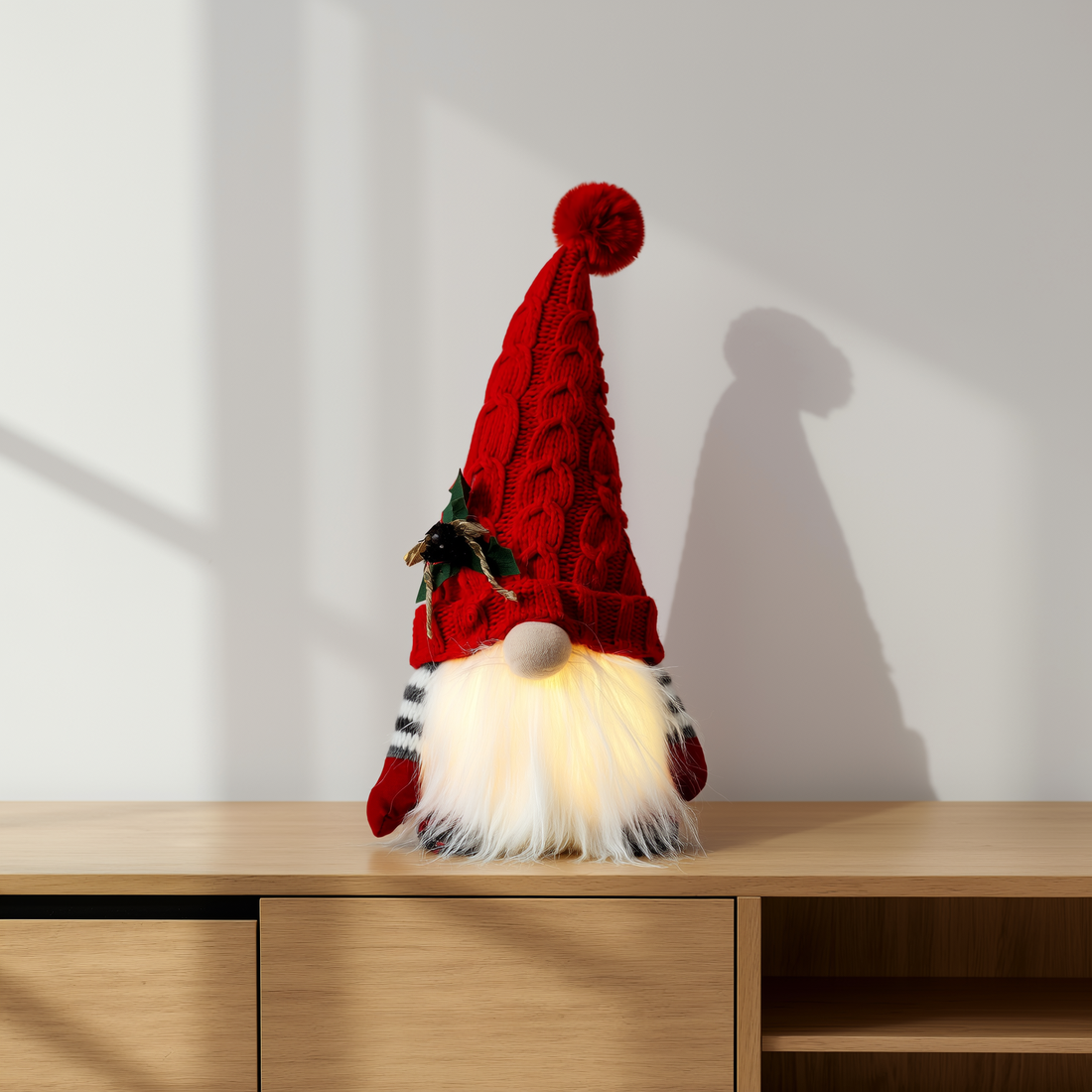 Gnomo de pelúcia com gorro de tricô vermelho e barba iluminada sobre aparador — foto de ambiente 1