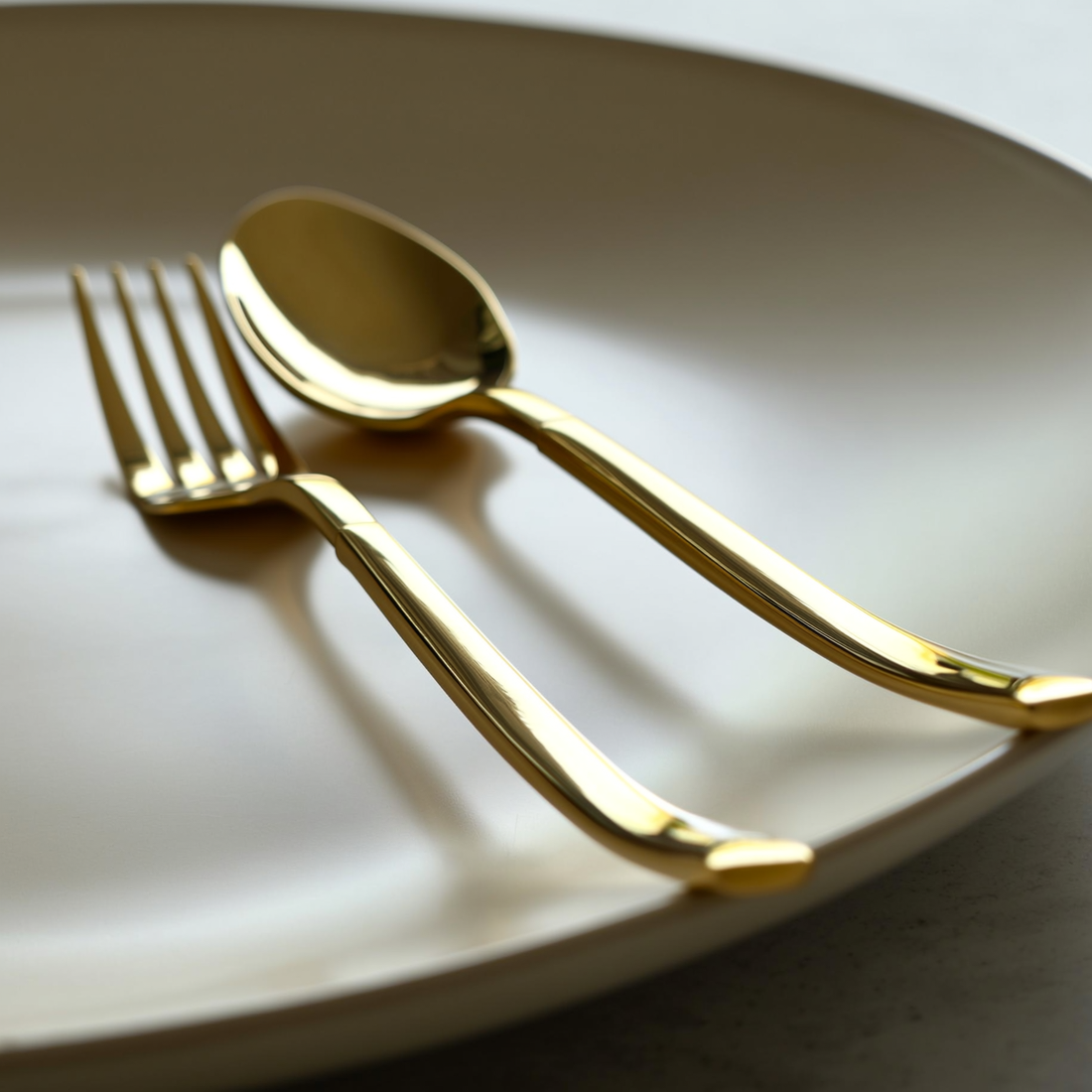 Kit de talheres dourado em mesa de jantar posta com guardanapo de linho — foto de ambiente 4