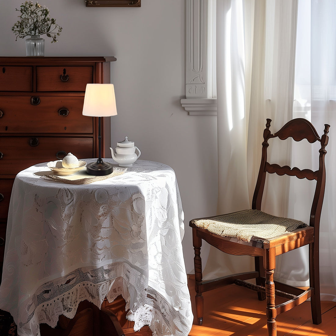 Abajur de mesa com cúpula de tecido e base dourada aceso sobre um aparador