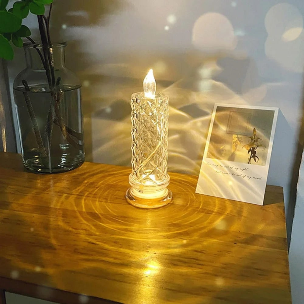 Vela de LED sem chama acesa com luz quente sobre uma superfície escura