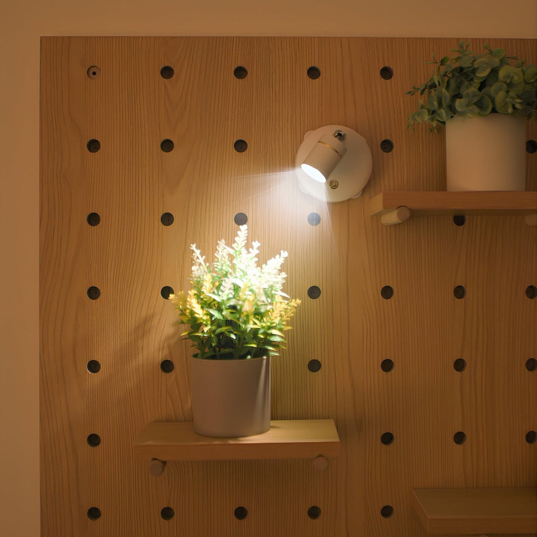 Arandela spot com cabeça inclinada iluminando um quadro na parede