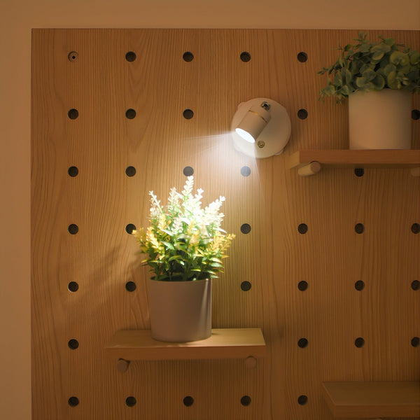 Arandela spot com cabeça inclinada iluminando um quadro na parede